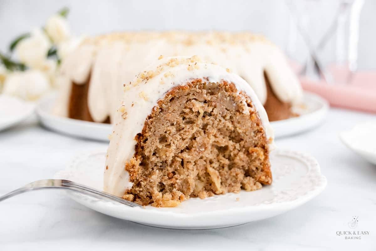 Large piece of carrot cake with glaze on a plate.