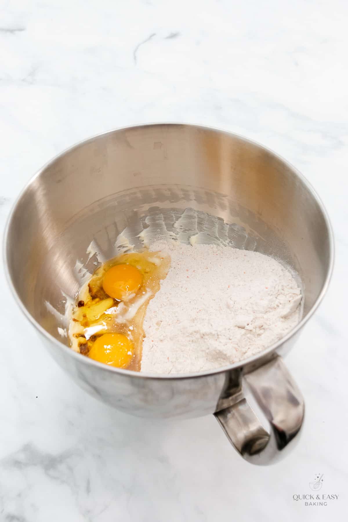 Adding eggs to cookie dough.
