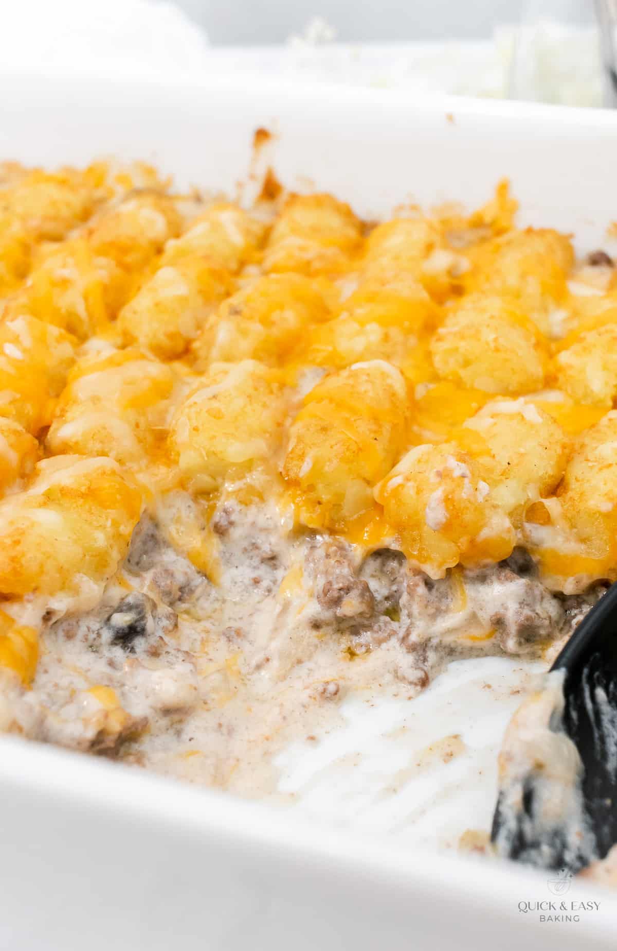 Casserole dish with tater tots and spoon.