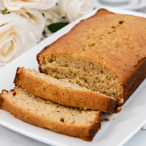 Banana bread on a white tray with slices.