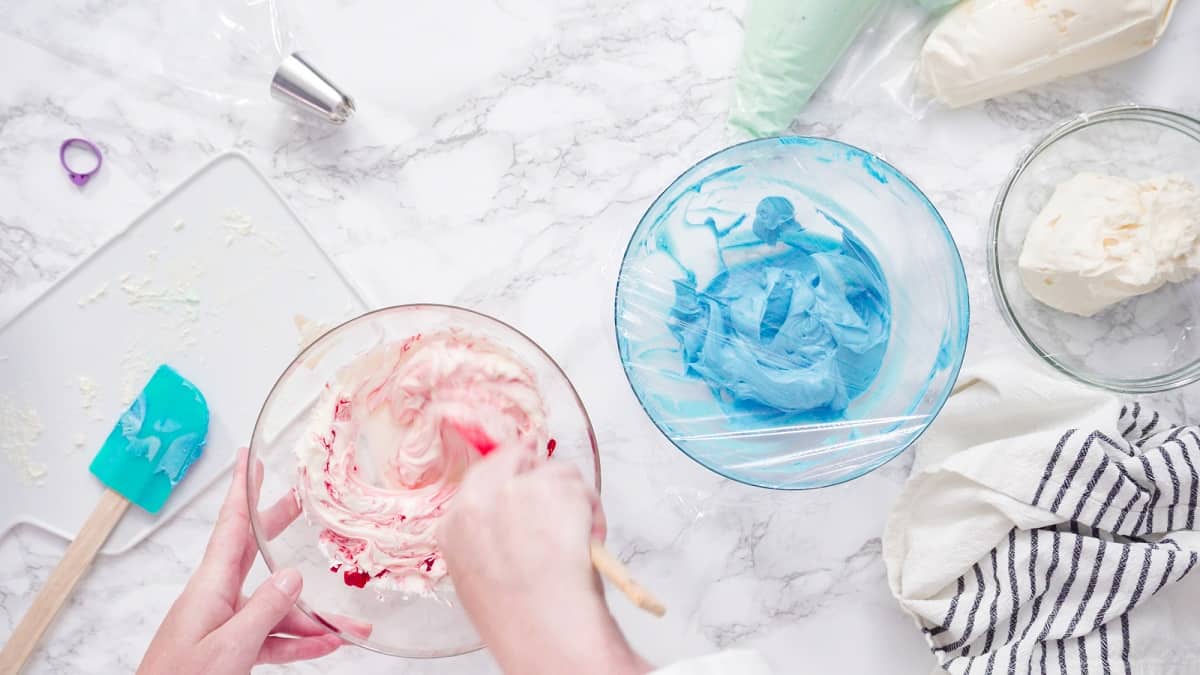 Colorful buttercream in glass bowls.