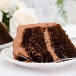 Large slice of chocolate sour cream cake on a plate with a fork.
