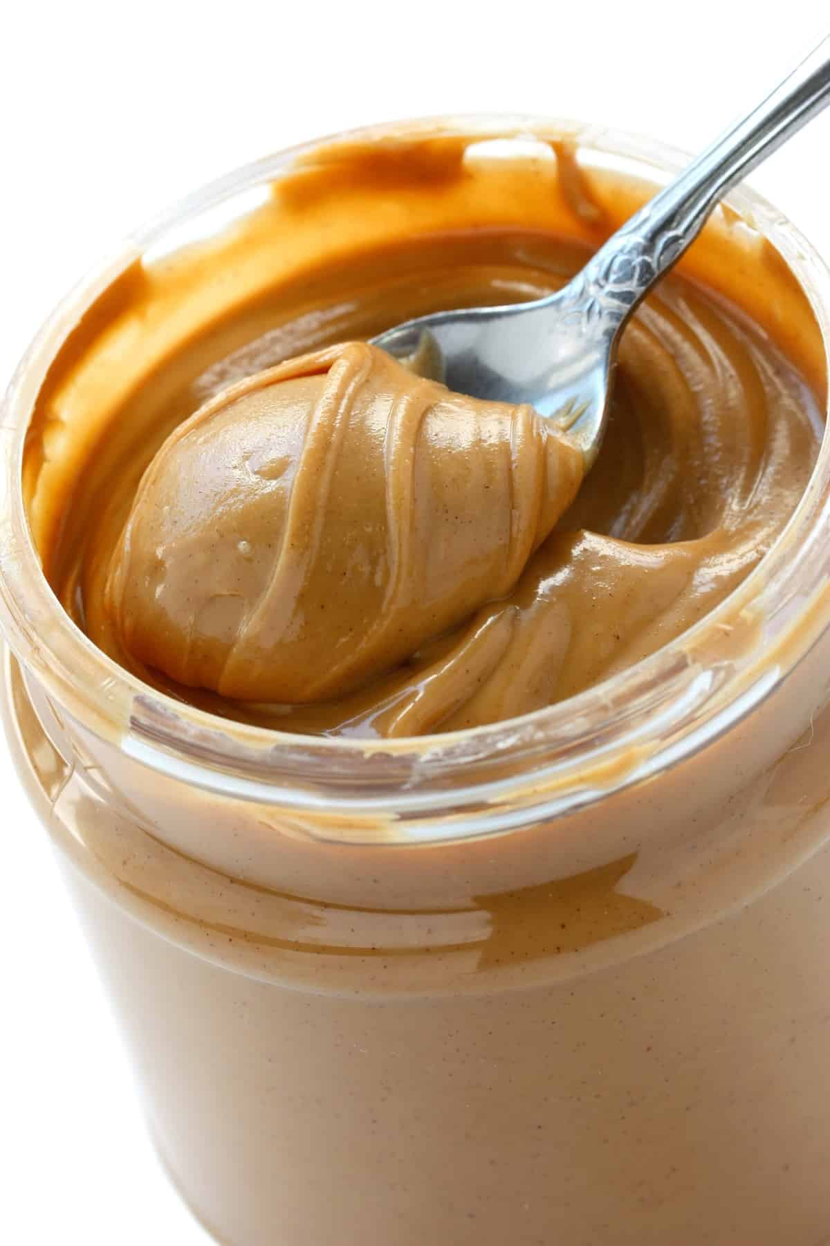 Peanut butter in jar with spoon.