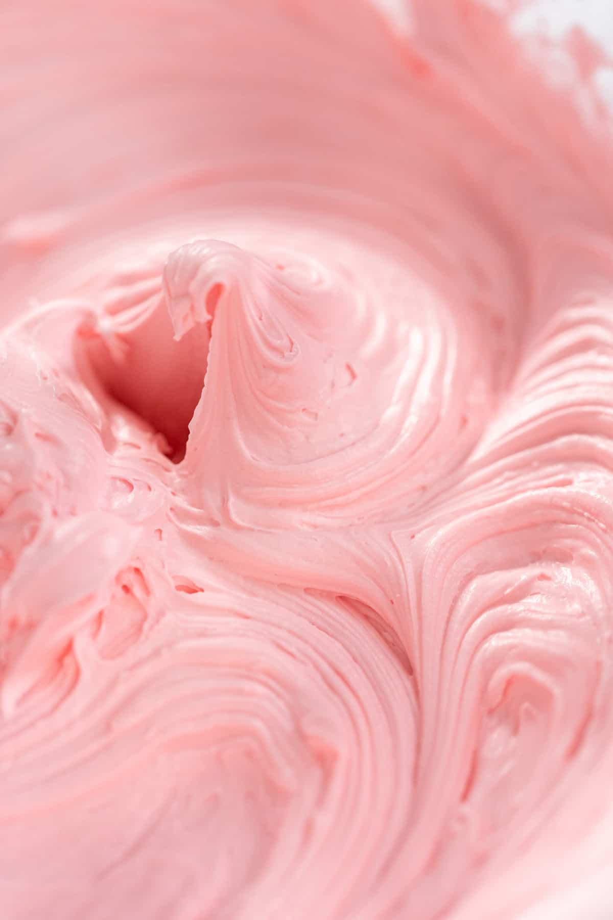 Pink buttercream in a bowl.