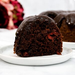 Large slice of cherry chocolate bundt cake on a white plate.