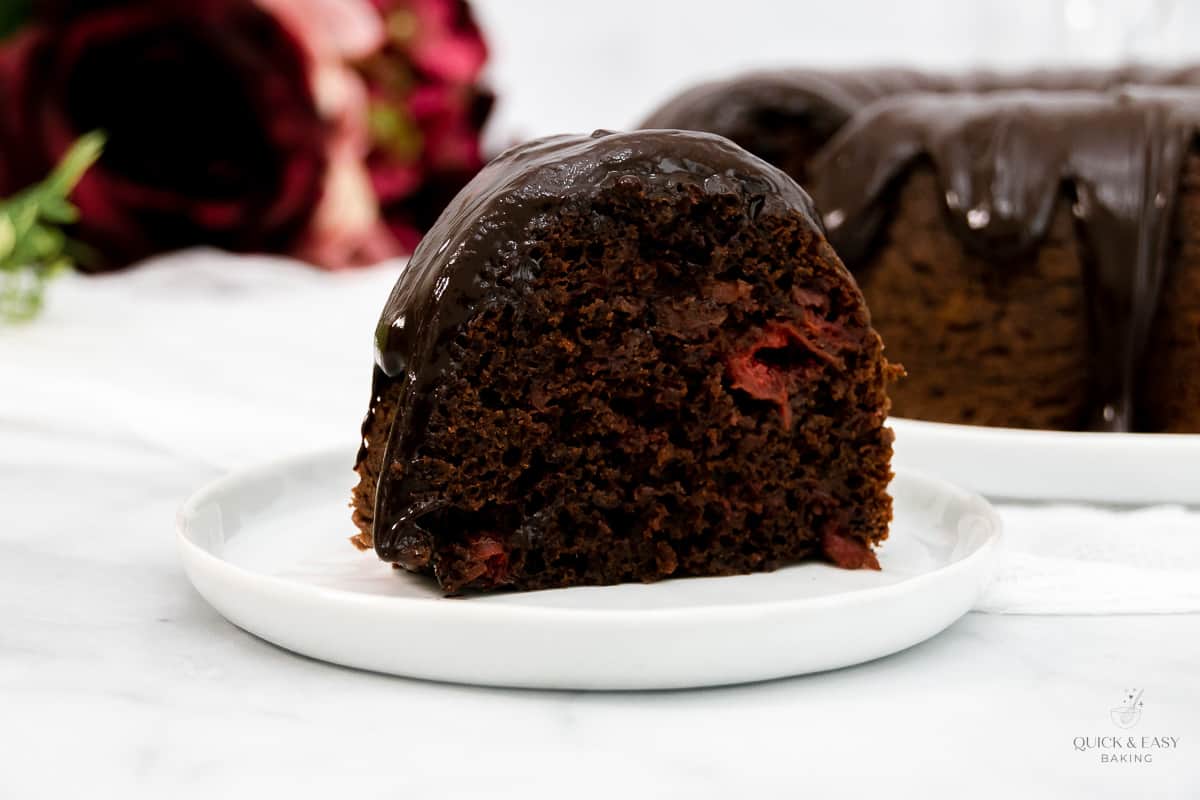 Large slice of chocolate cherry cake on a white plate.