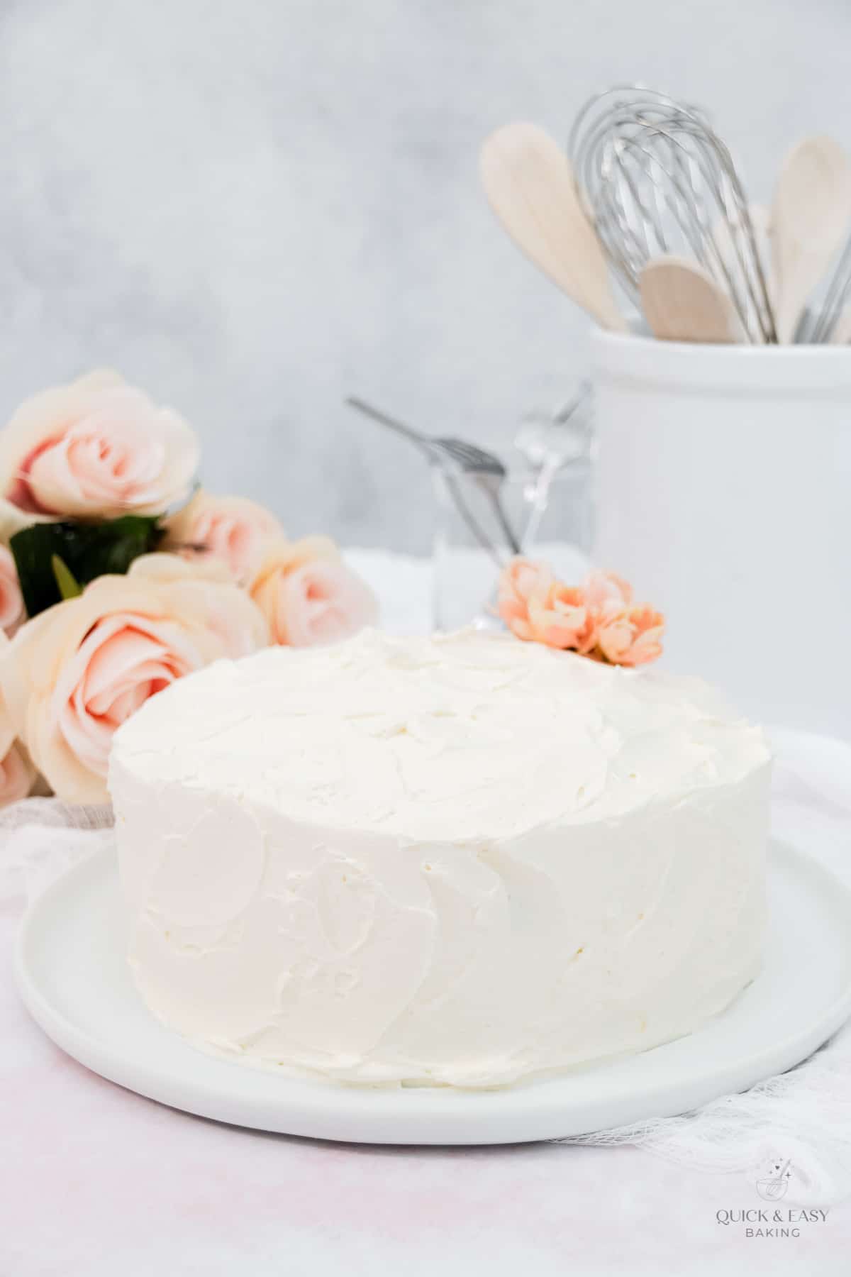 Frosted vanilla cake on a cake plate.