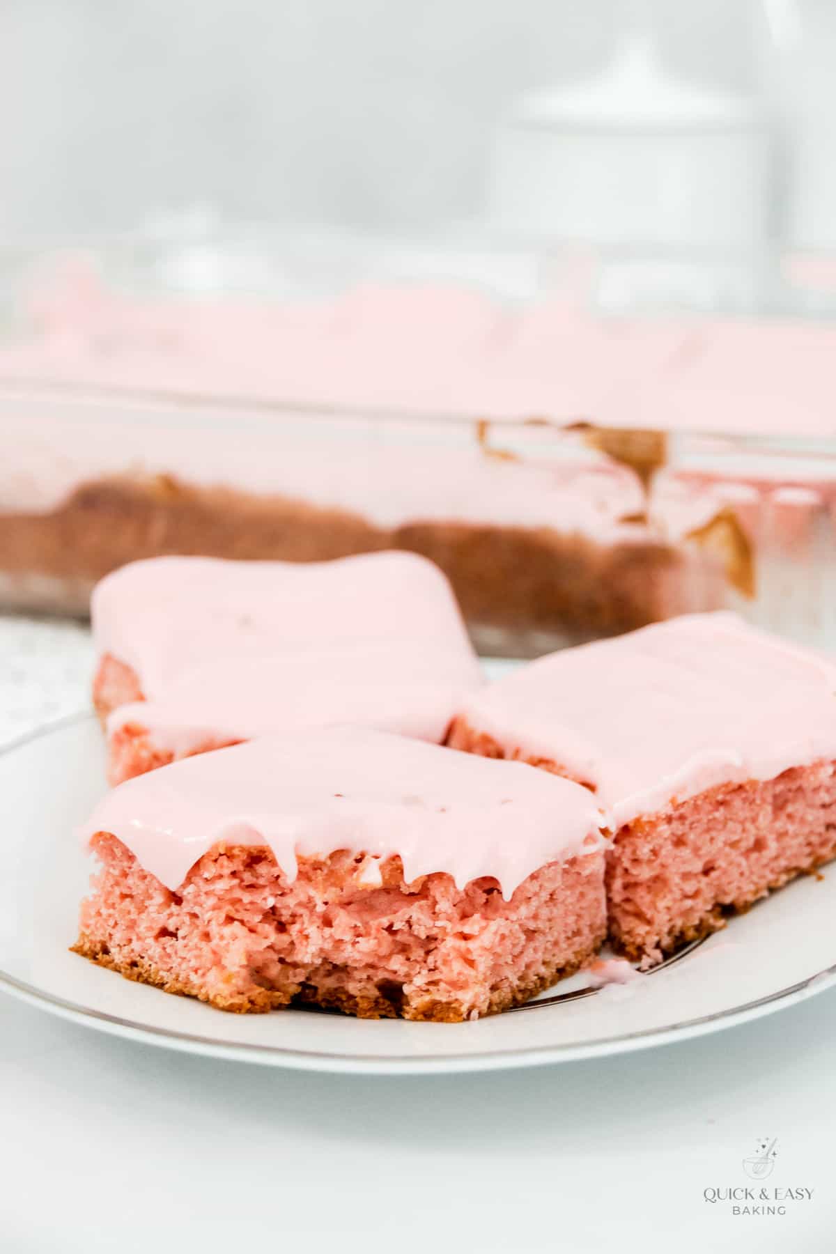 Strawberry cake bars with a bite taken out.