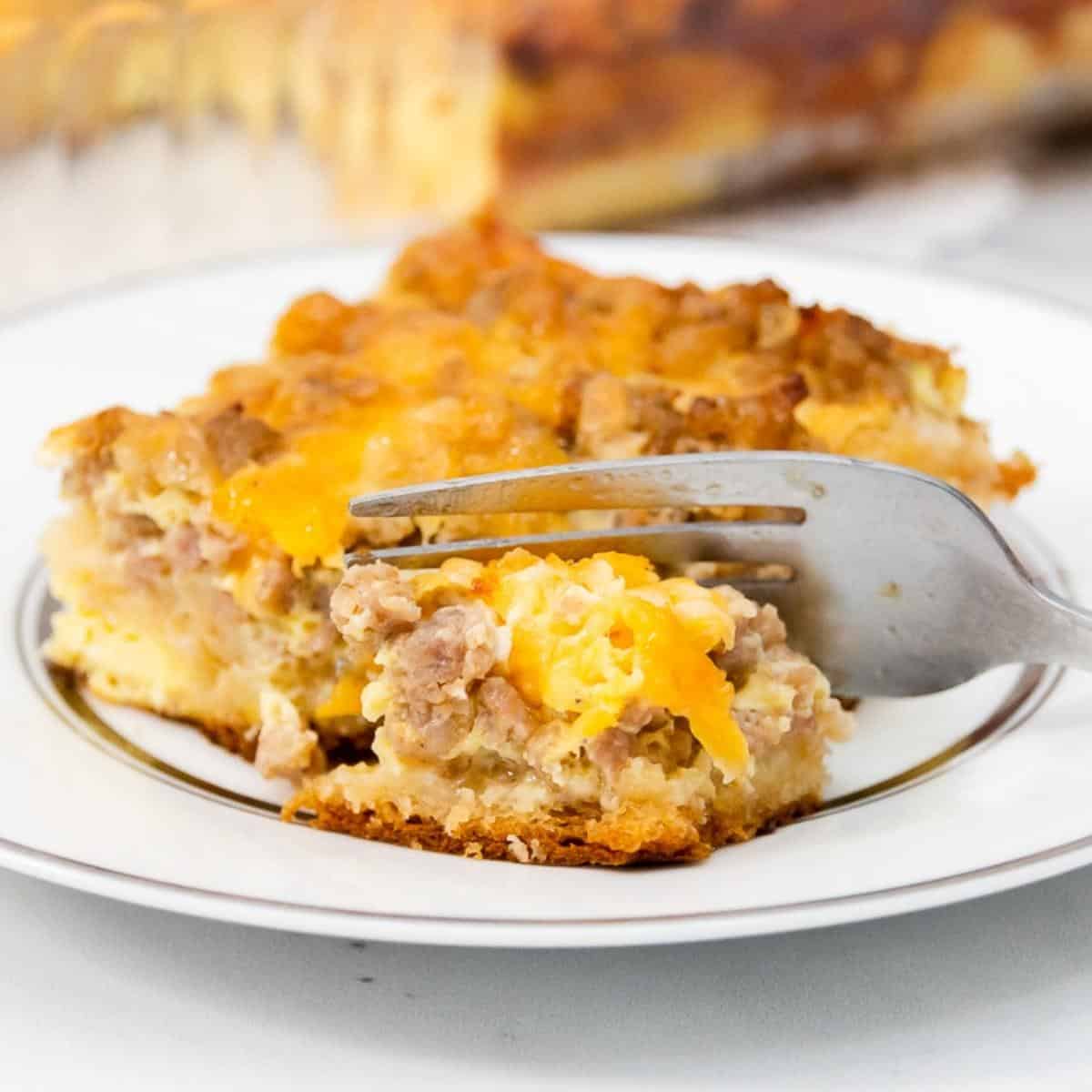 Featured image with fork and breakfast casserole on a white plate.