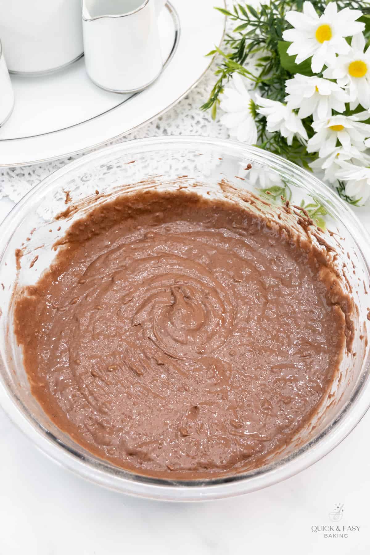 Mixed chocolate banana bread batter in a glass bowl.