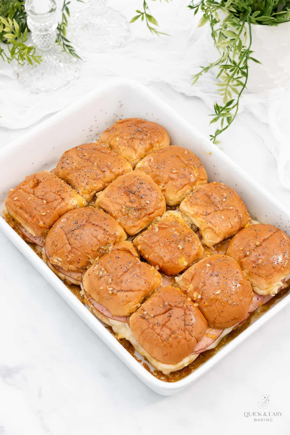 Top view of baked sliders in a white dish.