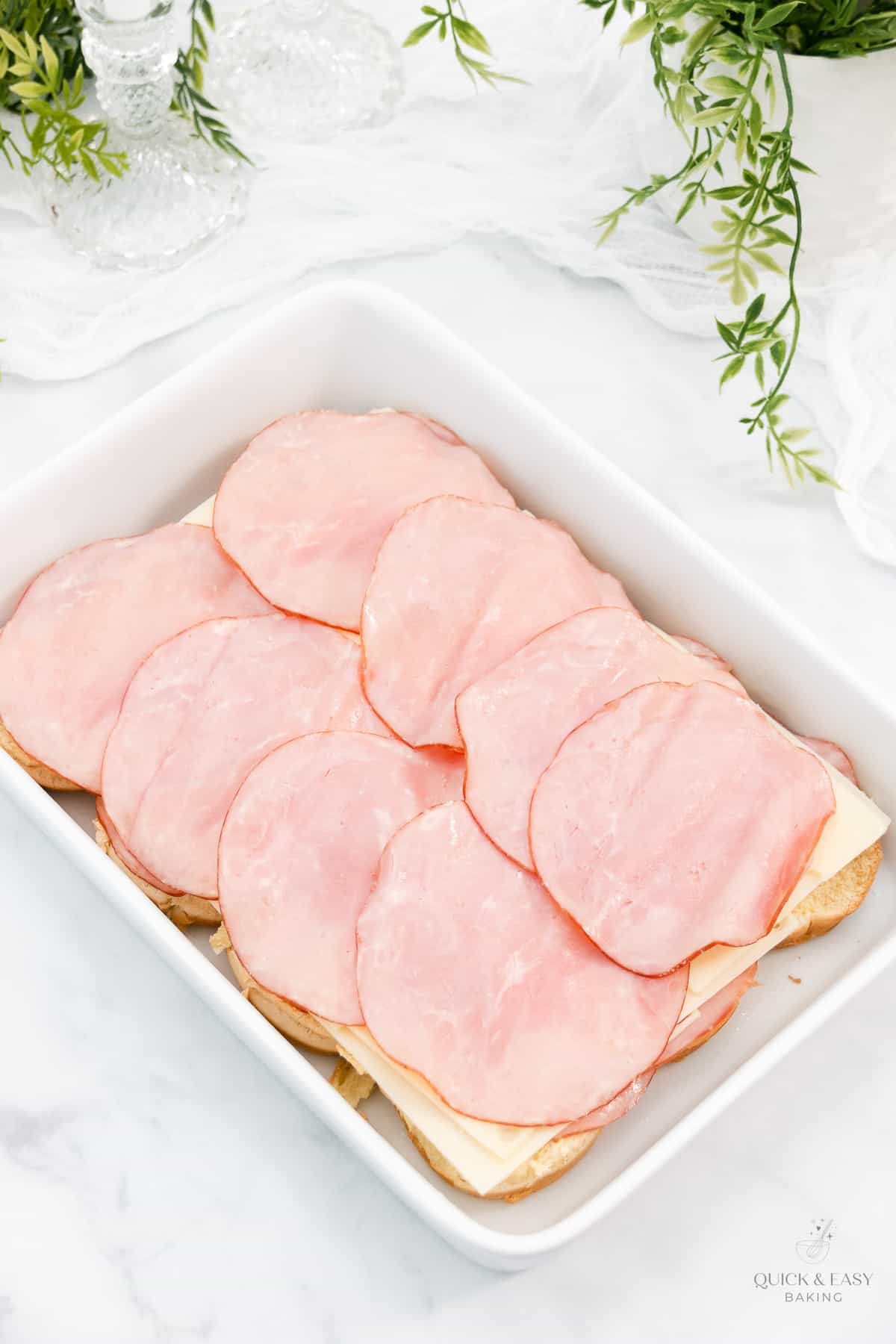 Rolls with ham and cheese in a casserole dish.
