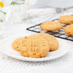 Three peanut butter cookies on a white plate featured image.
