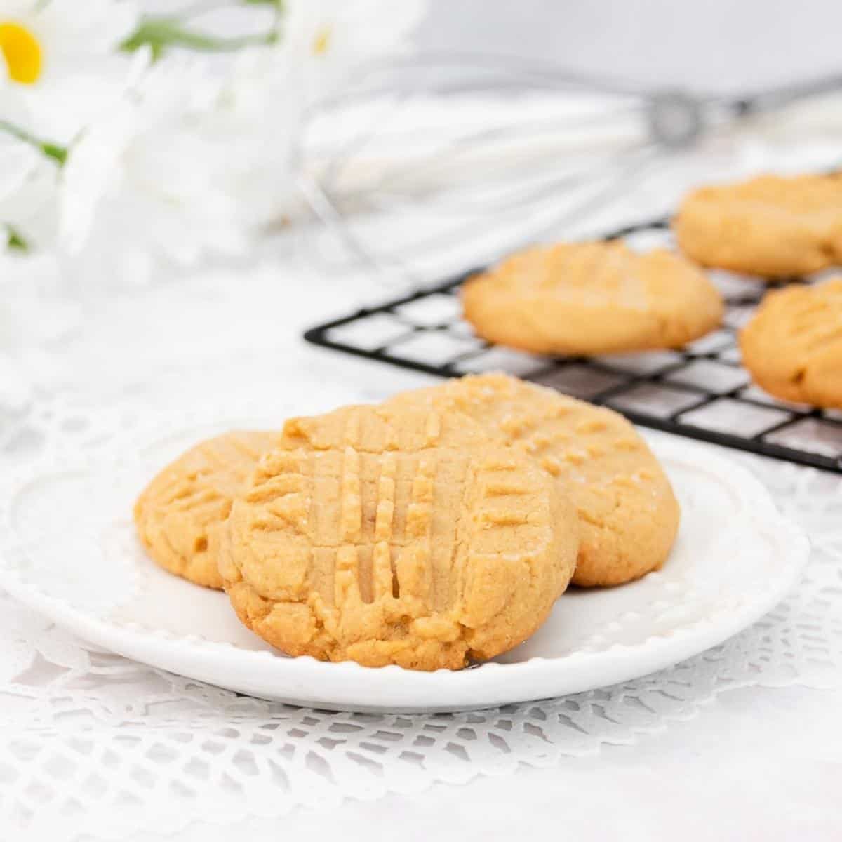 Three peanut butter cookies on a white plate featured image.