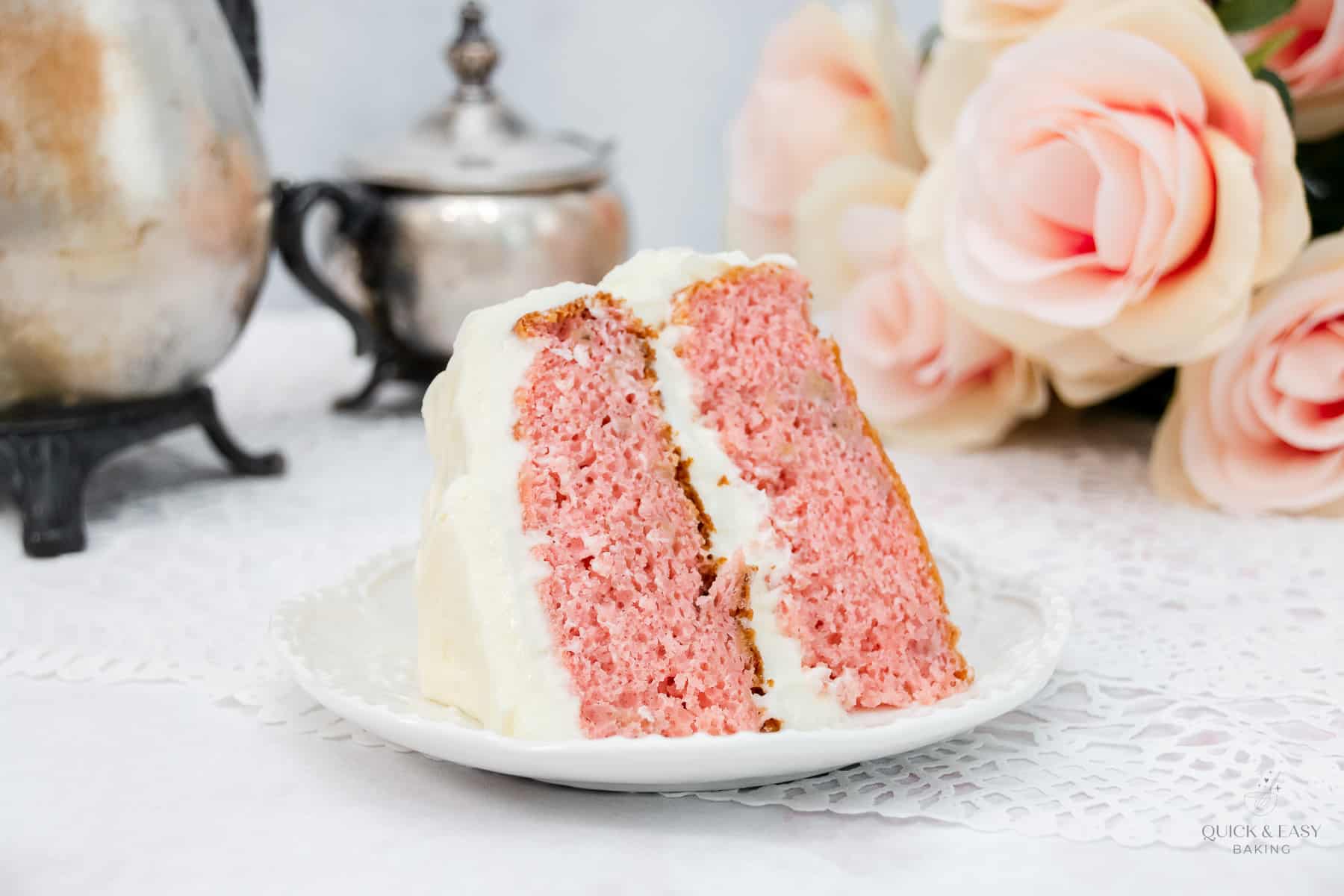 Large slice of banana cake with strawberry on a white plate.