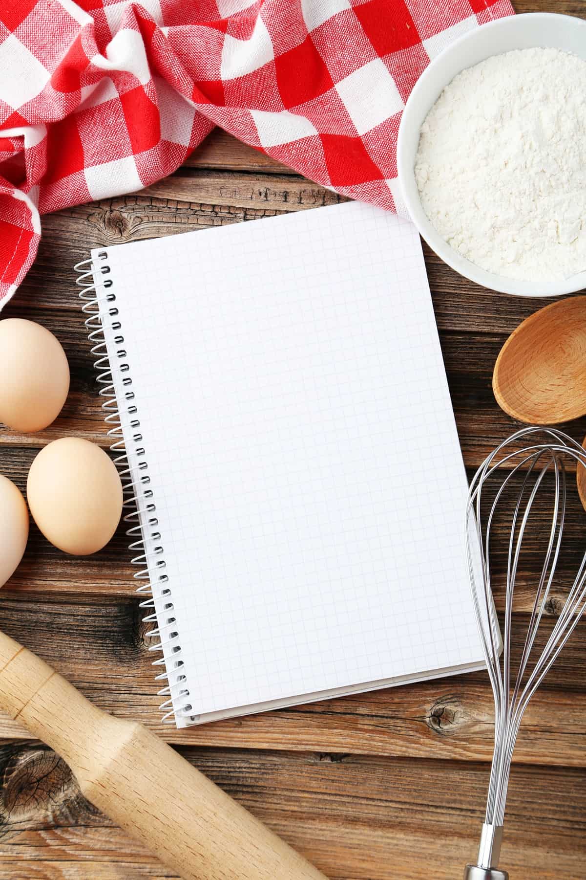 Recipe book with whisk and baking ingredients.