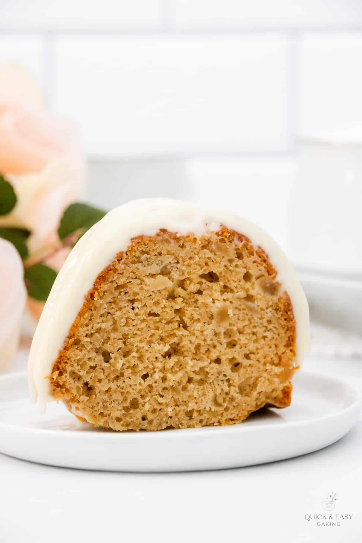 Close up of slice of easy apple bundt cake on a white cake.