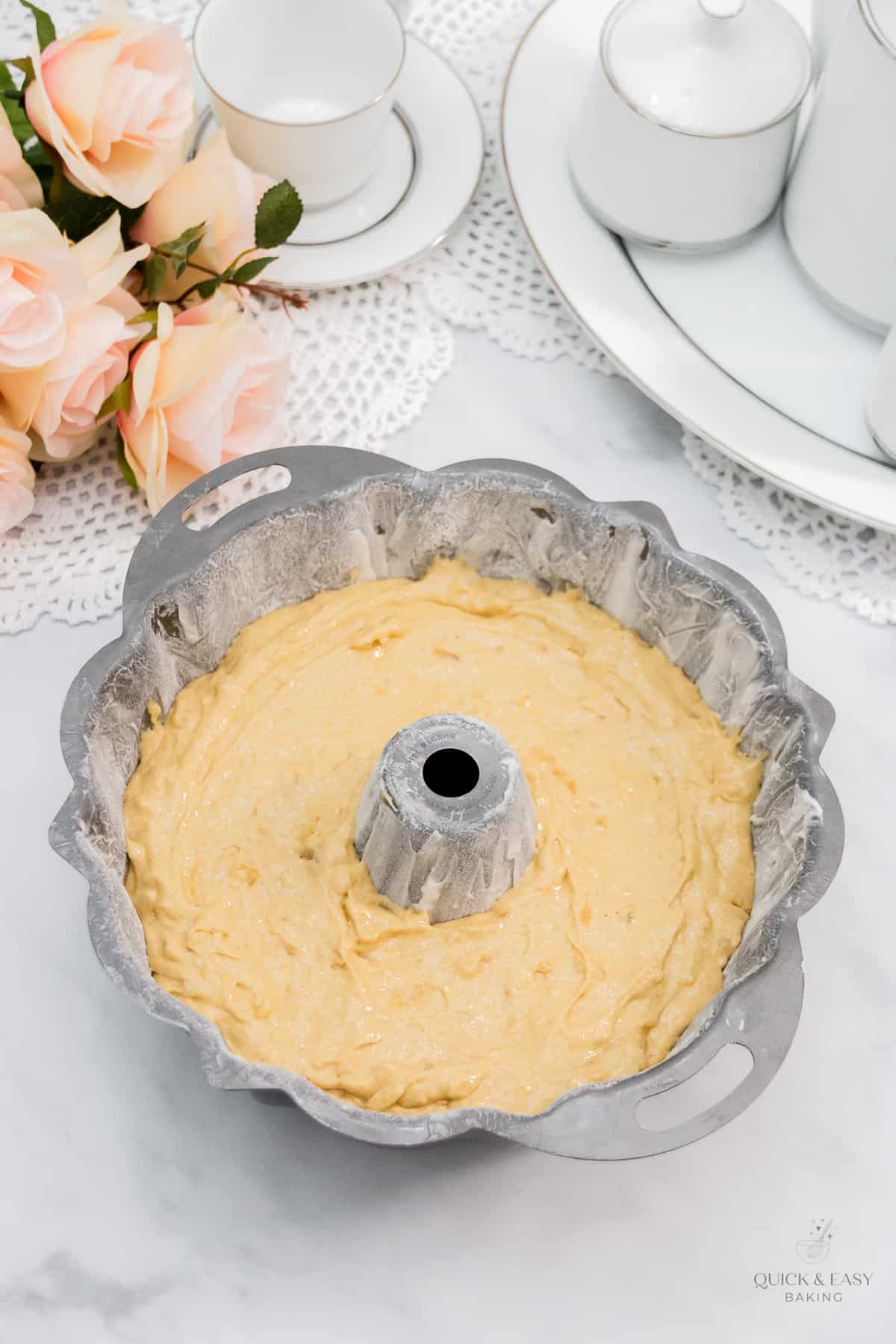 Cake batter with apples in a bundt pan.