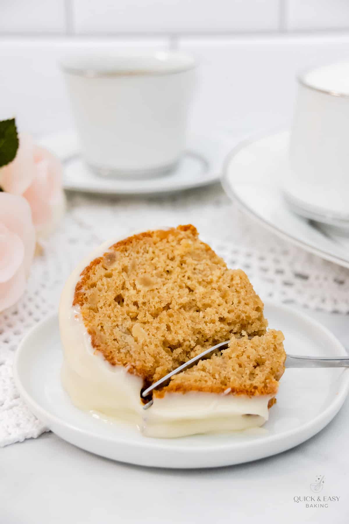 Slice of apple cake with a fork in it on a plate.