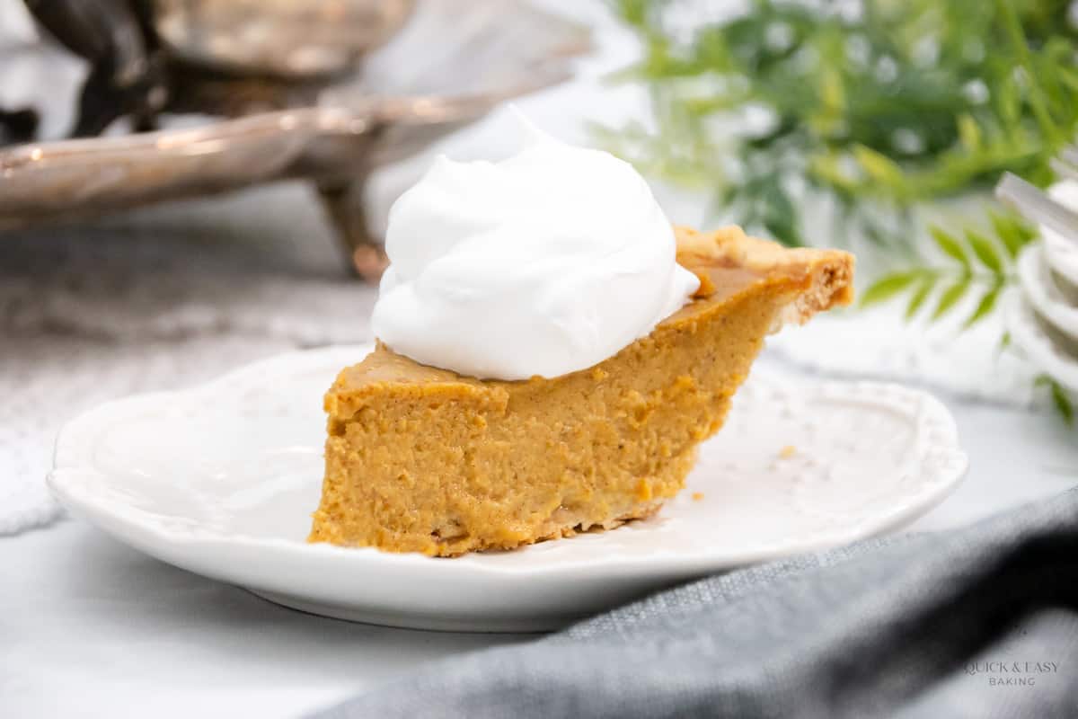 Large slice of pumpkin pie with cool whip.