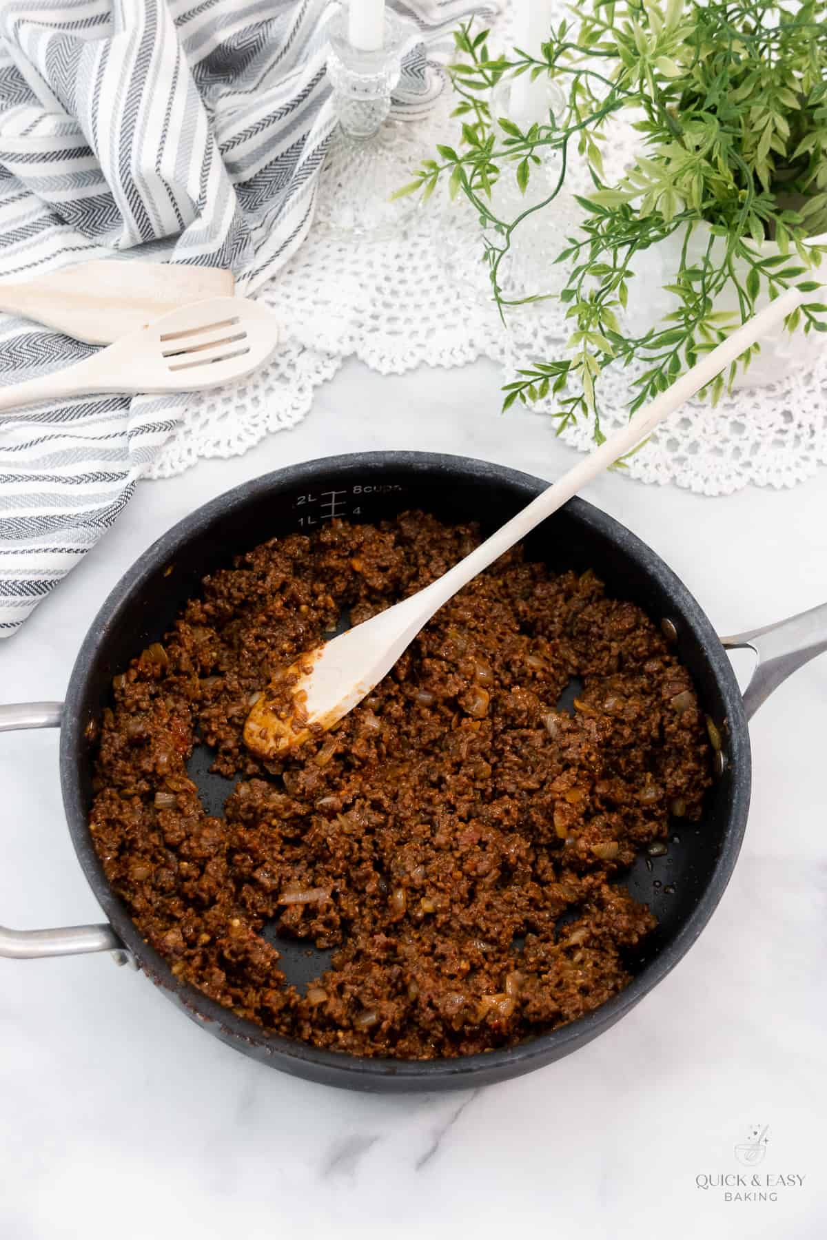 Cooked beef mixture with spices in a large skillet.