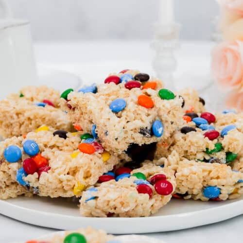 Wide image of stack of m&m rice crispy treats on a white platter.