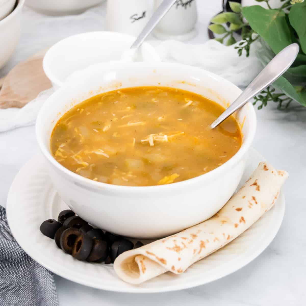 Green chicken chili verde soup in a white bowl with a spoon featured image.