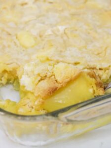 Large serving spoon in a baking dish with easy lemon dump cake.