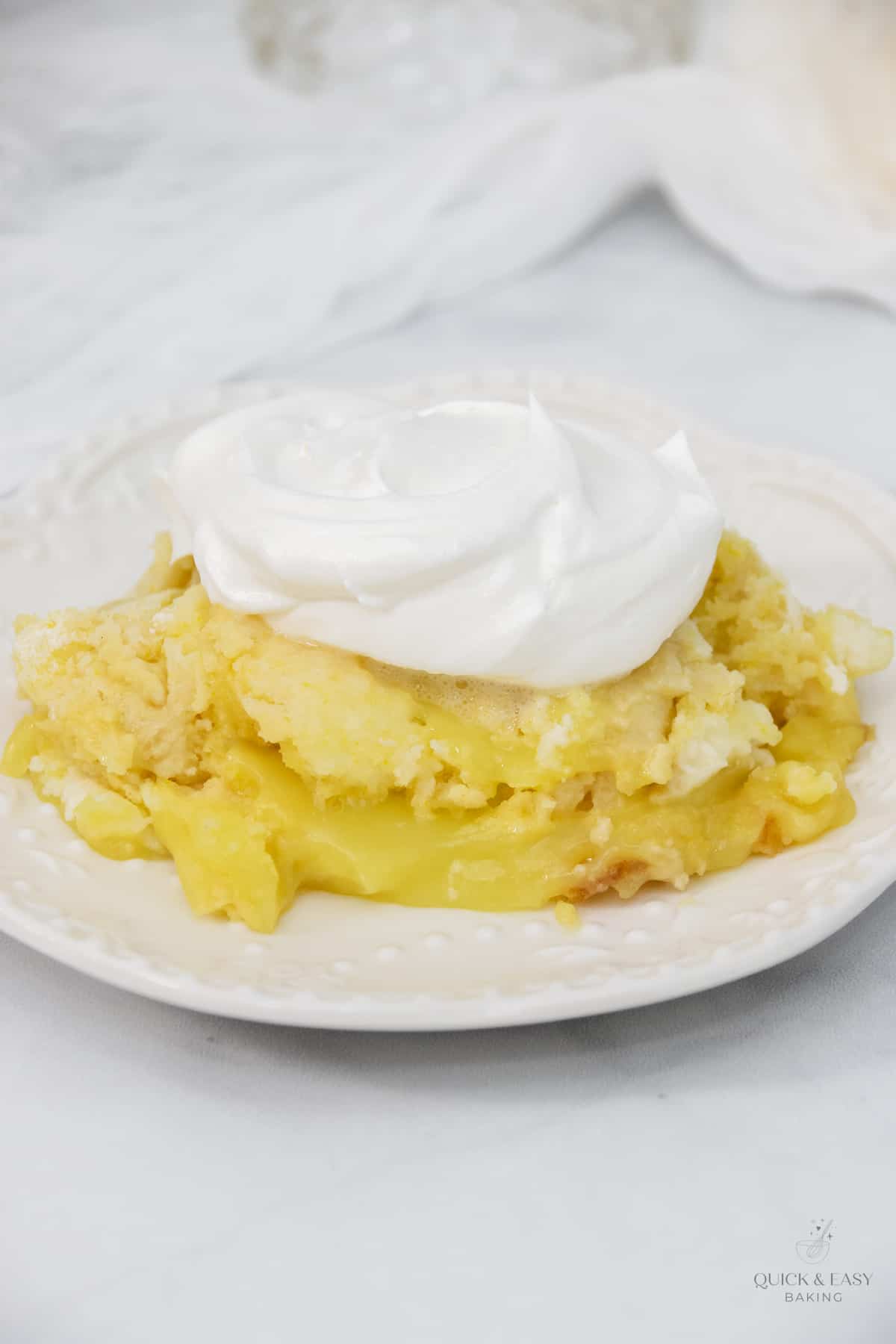 Top down image of an easy lemon cake with cool whip on top.