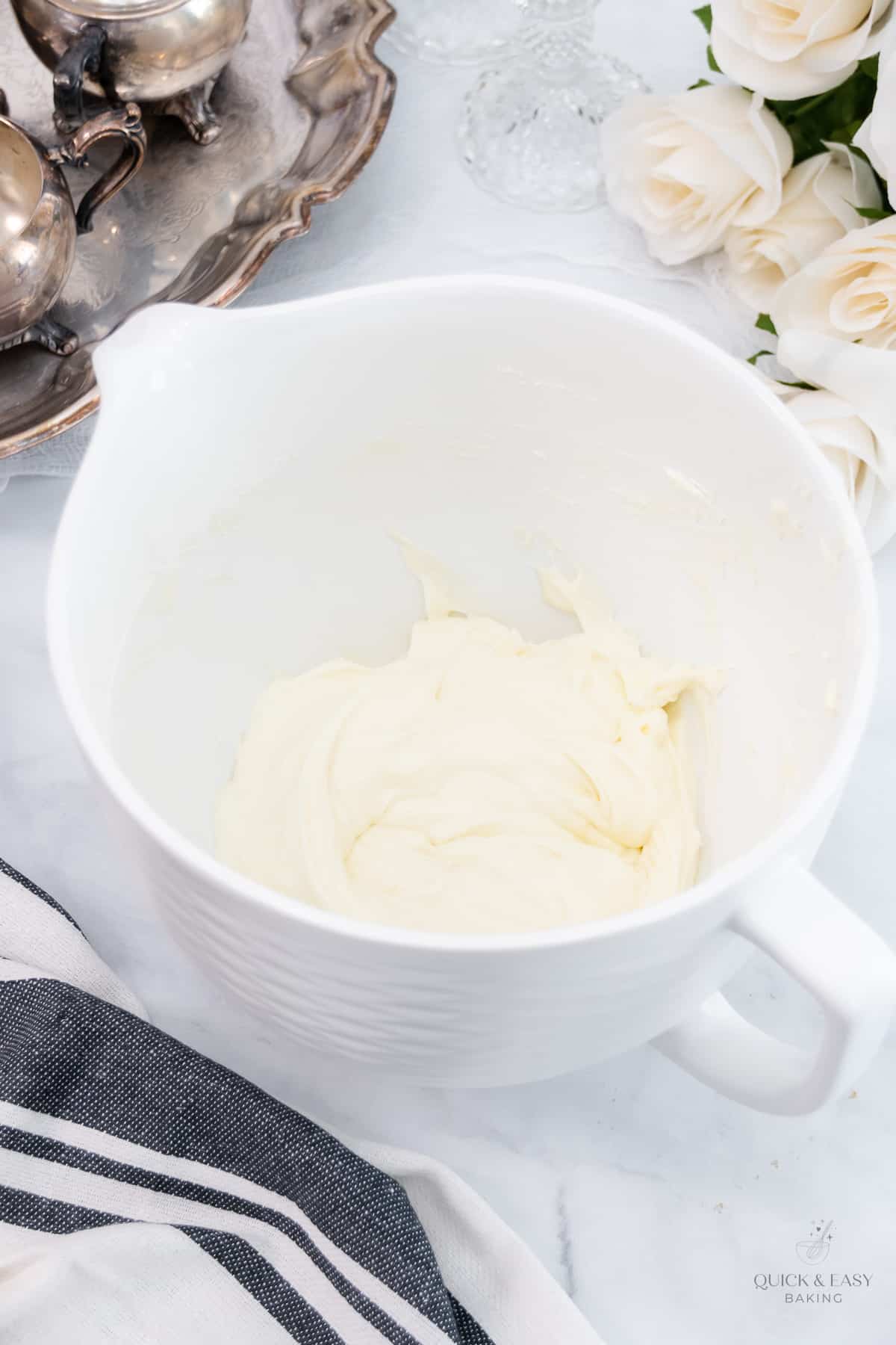 Mixed cream cheese in a white mixing bowl.