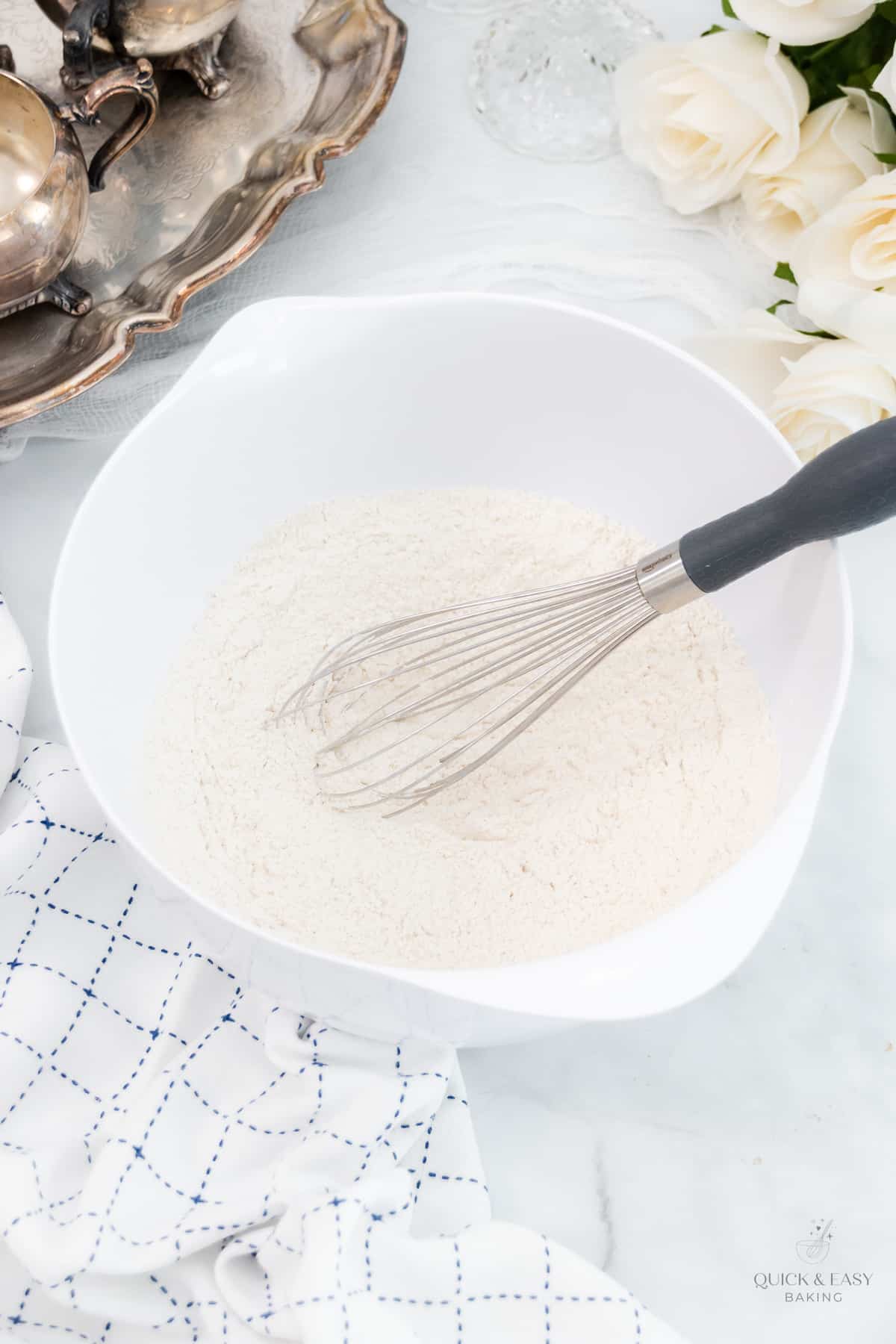 Dry ingredients in a white mixing bowl with a whisk.