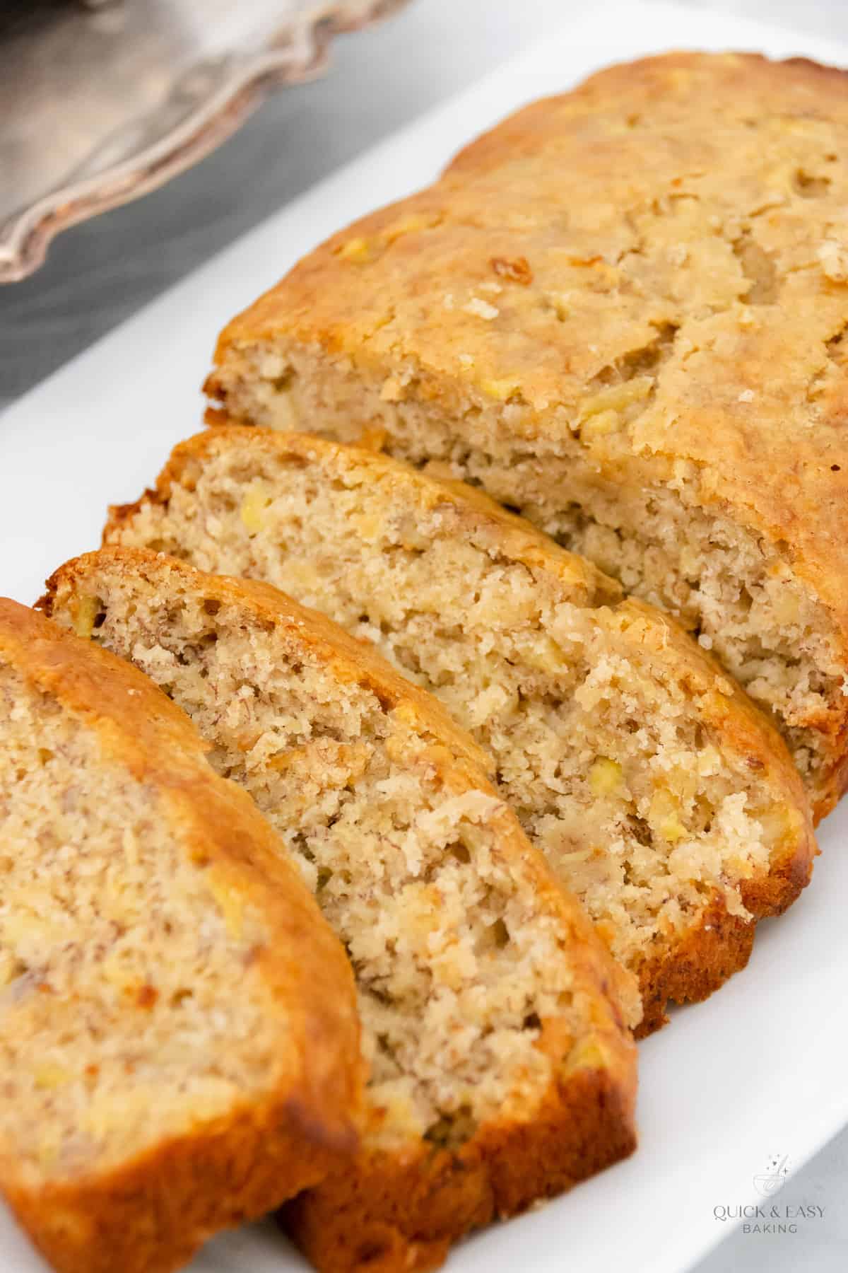 Close up of banana bread on a white platter.