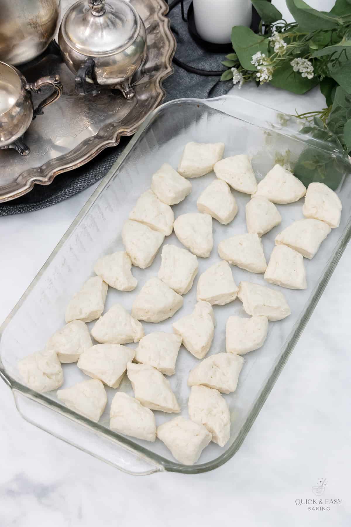 Biscuit dough added to baking dish.