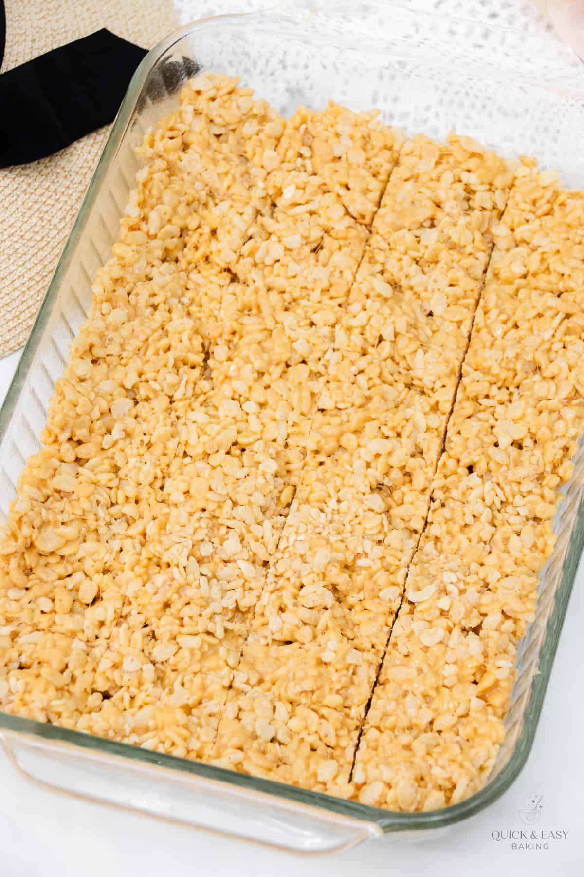 Peanut butter rice krispie treats cut into squares in a baking dish.