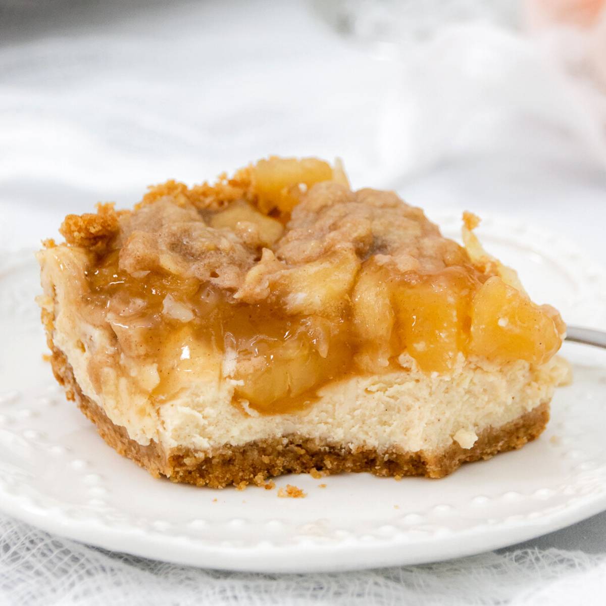Large slice of apple crisp cheesecake featured image.