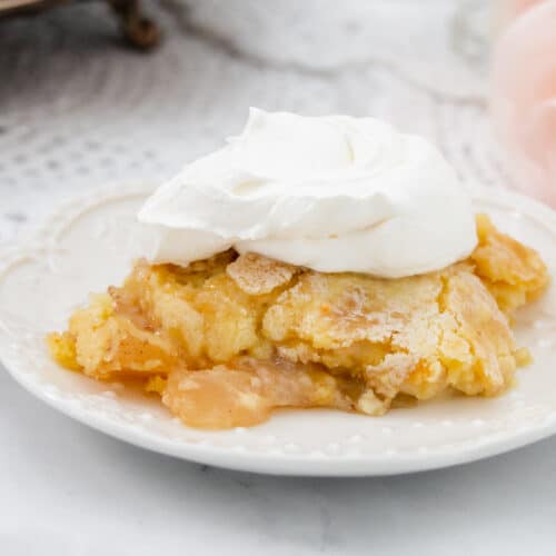 Large slice of warm apple cake on a white plate.