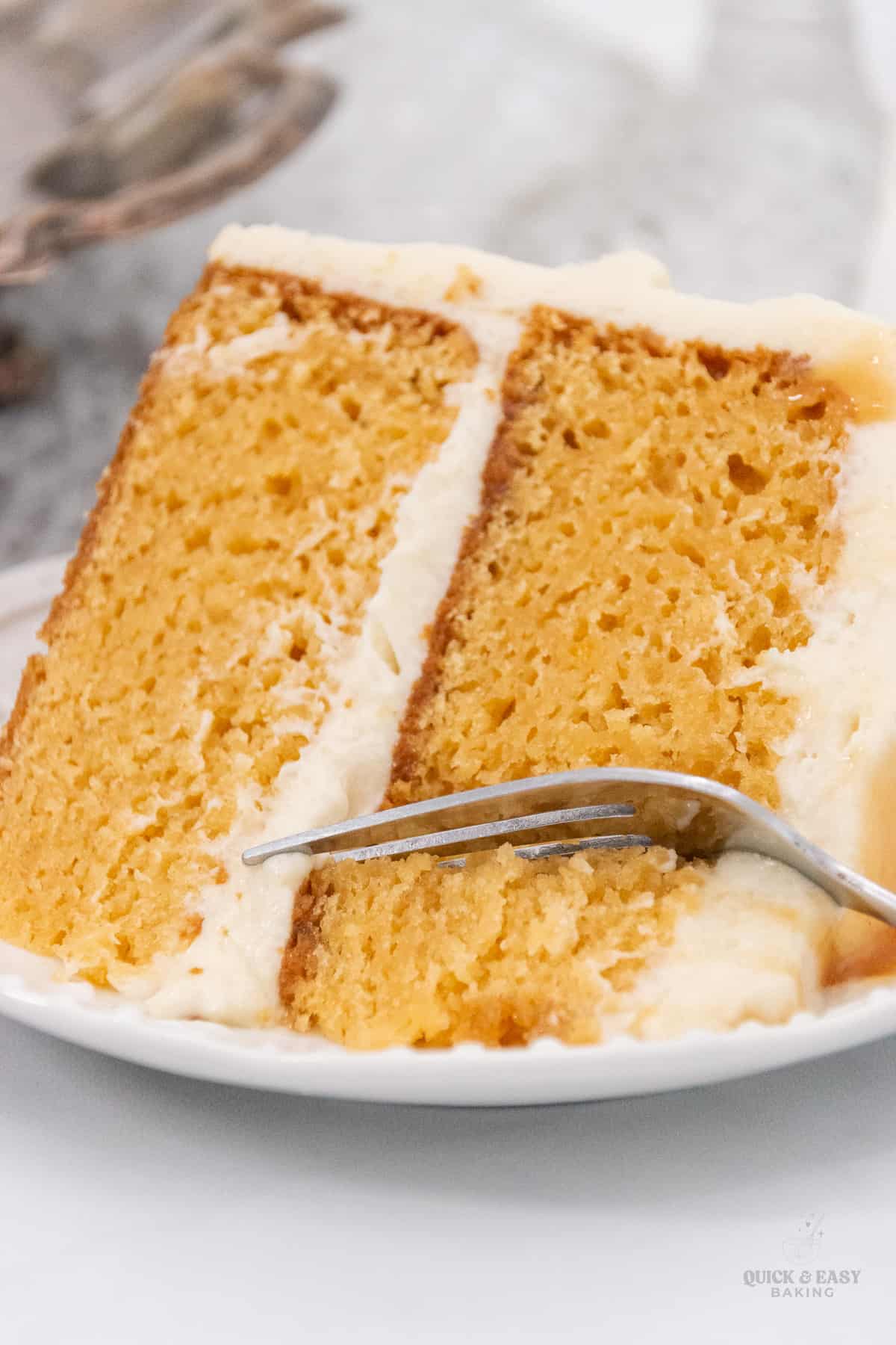 Close up image of easy caramel cake made with a cake mix with a fork on a white plate.