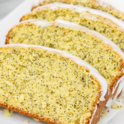 Close up of lemon poppy seed bread on a white plate.